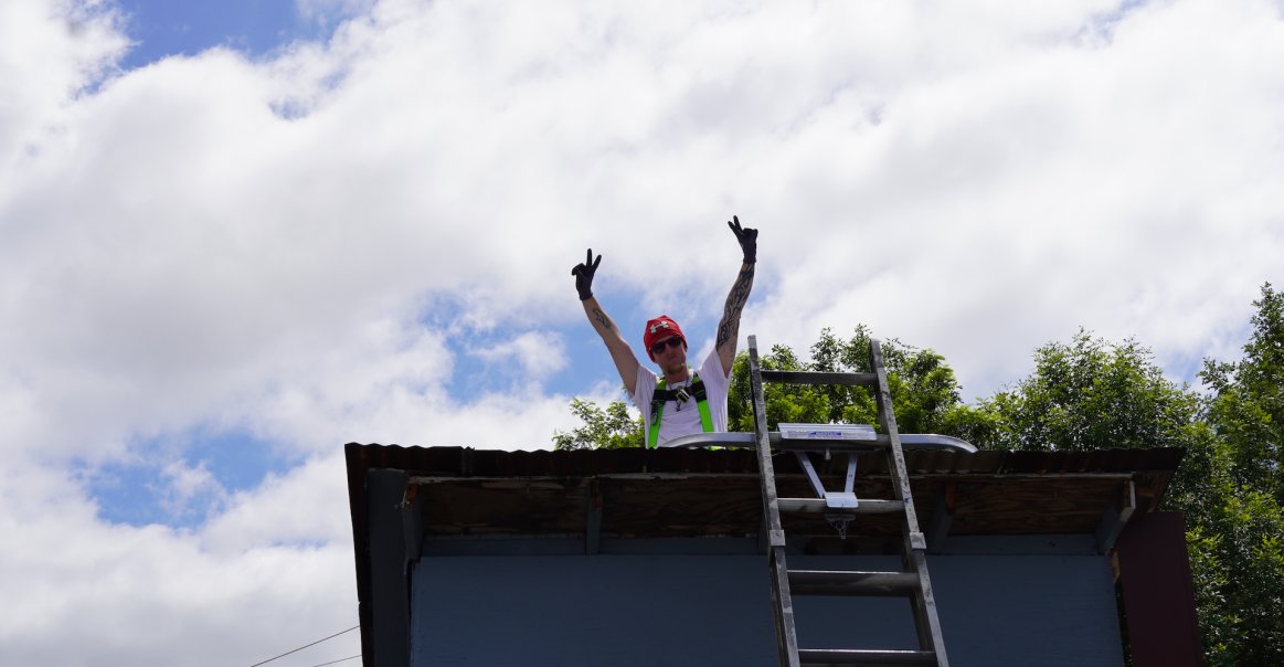 Solar Volunteer Team Peace Signs on Roof