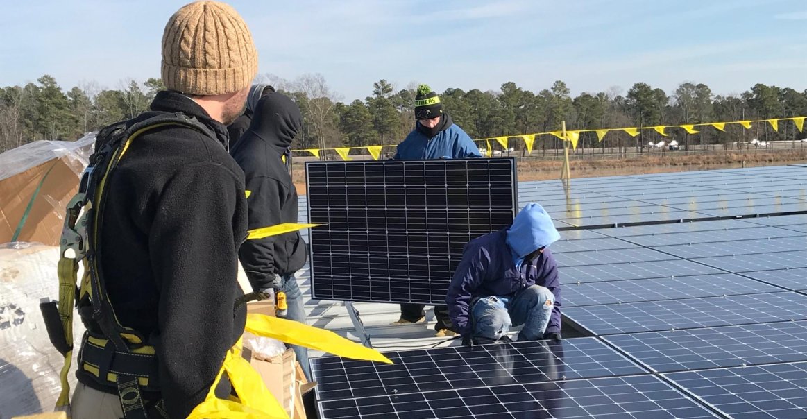 Solar Installers Carry Solar Panels on Commercial Job Site